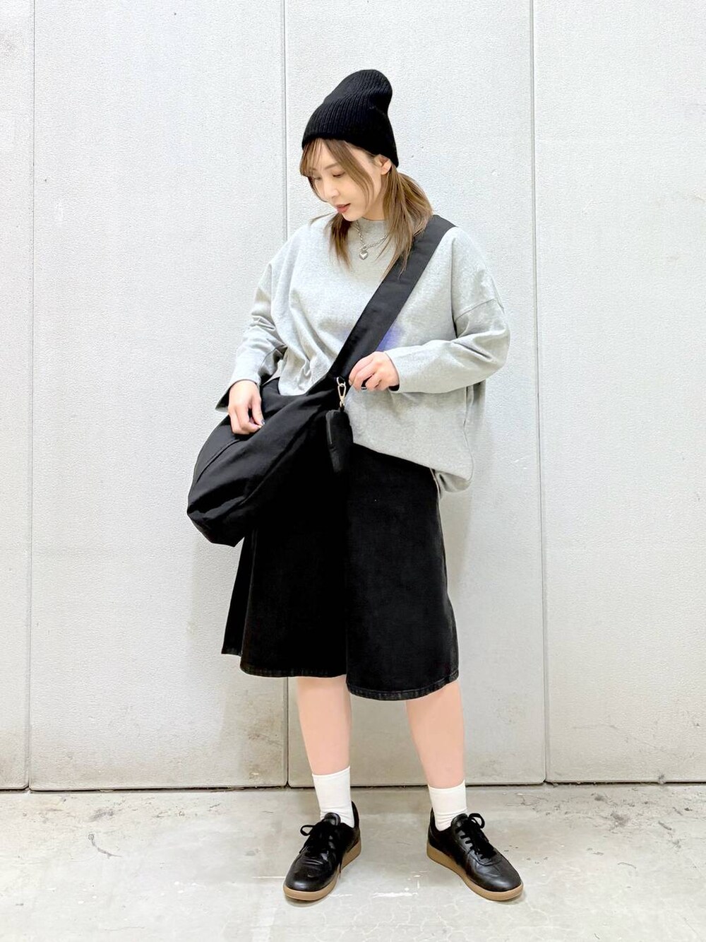 グレー系のワンピース、ブラック系のショルダーバッグ、ブラック系のスニーカーを着用したレディースの春コーディネートの2枚目の写真