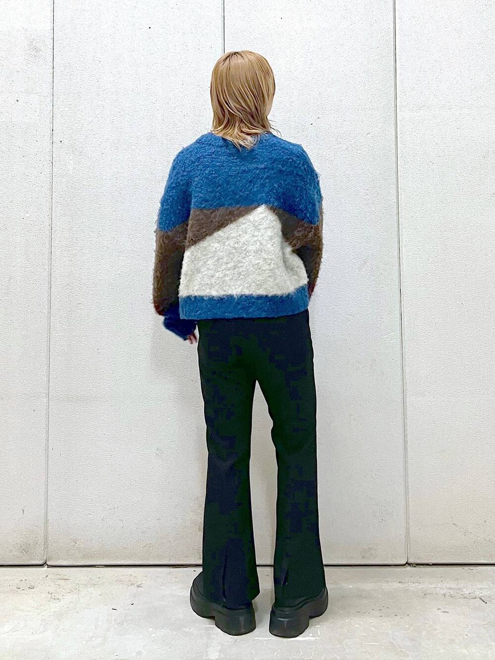 ブラック系のブーツ、ブラック系のスラックス、ブラウン系のニット/セーターを着用したレディースの冬コーディネートの2枚目の写真