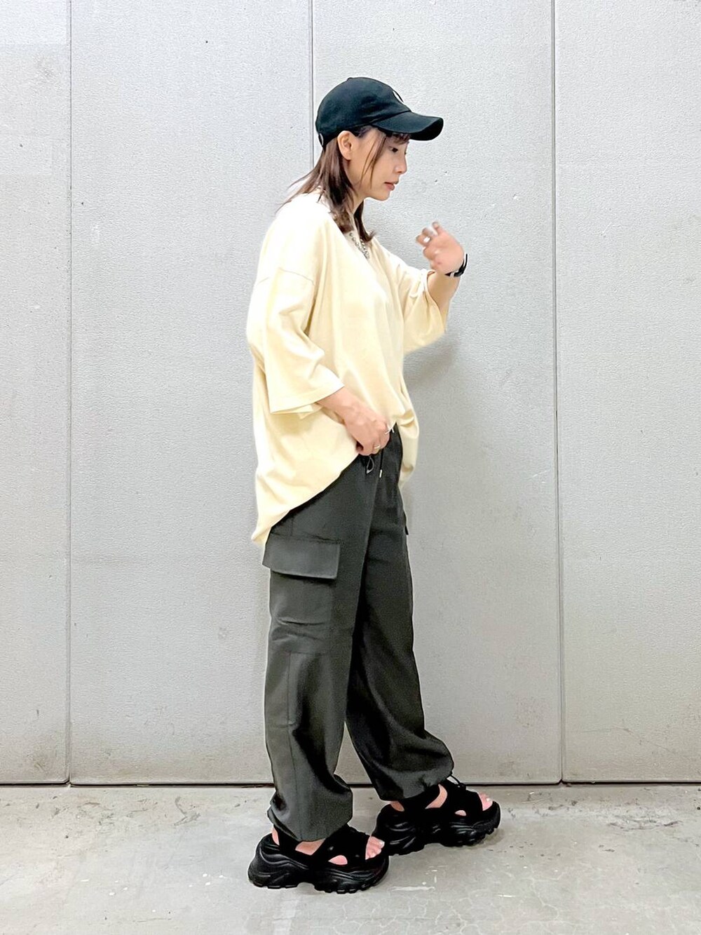 ブラック系のサンダル、グレー系のカーゴパンツ、ホワイト系のTシャツ/カットソーを着用したレディースの夏コーディネートの3枚目の写真
