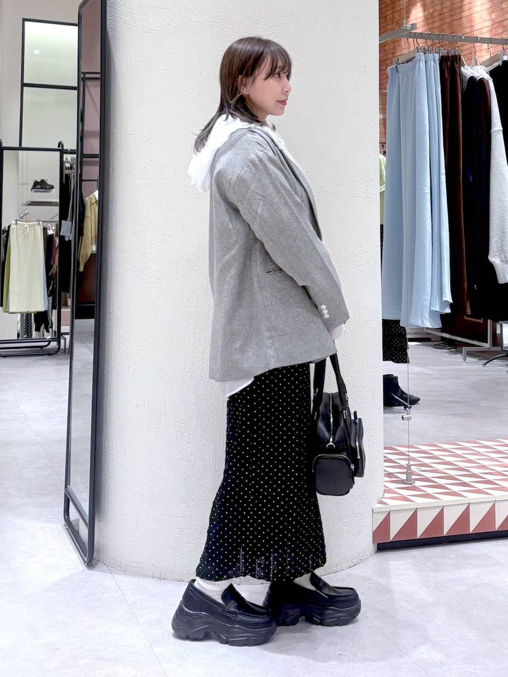 ホワイト系のシャツ/ブラウス、グレー系のテーラードジャケット、ブラック系のボストンバッグを着用したレディースの冬コーディネートの4枚目の写真