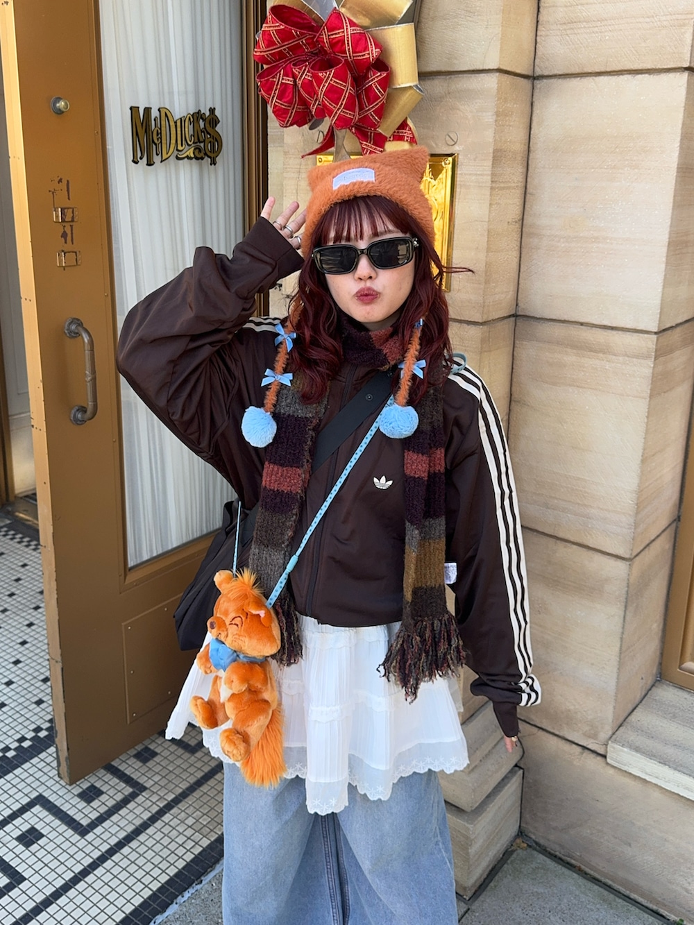 ブルー系のデニムパンツ、ブラウン系のジャージ、ホワイト系のスカートを着用したレディースの冬コーディネートの2枚目の写真