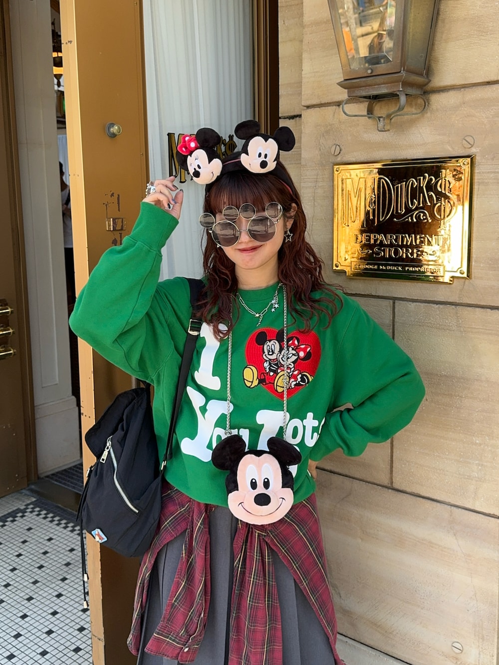 グレー系のスカート、ブラック系のスニーカー、グリーン系のスウェットを着用したレディースの秋コーディネートの2枚目の写真