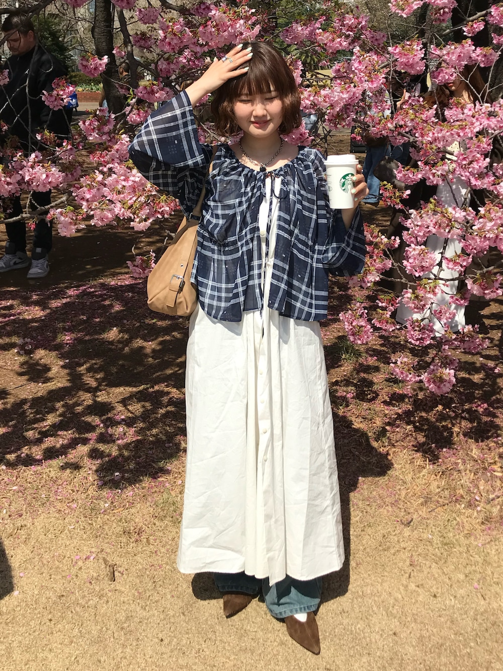 ブルー系のデニムパンツ、イエロー系のハンドバッグ、ブルー系のシャツ/ブラウスを着用したレディースの春コーディネートの2枚目の写真