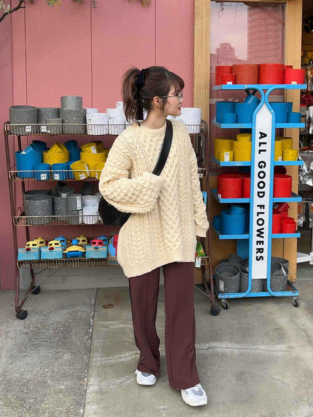 グレー系のスニーカー、ブラウン系のスラックス、ベージュ系のニット/セーターを着用したレディースの冬コーディネートの3枚目の写真