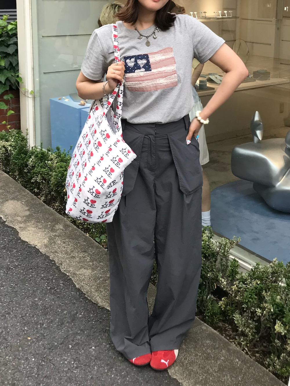 グレー系のパンツ、レッド系のスニーカー、グレー系のTシャツ/カットソーを着用したレディースの夏コーディネートの2枚目の写真