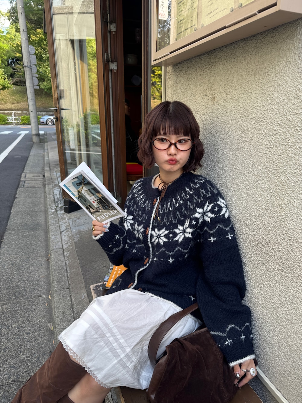 ブルー系のカーディガン/ボレロ、ホワイト系のスカート、ブラウン系のブーツを着用したレディースの秋コーディネートの3枚目の写真