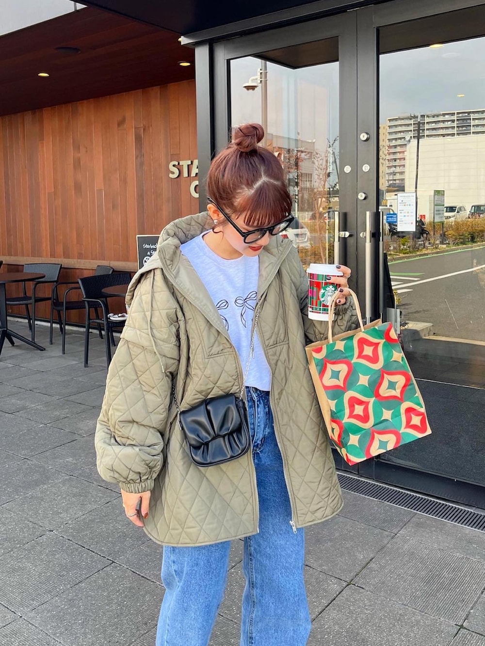 ブルー系のデニムパンツ、グリーン系のダウンジャケット/コートを着用したレディースの冬コーディネートの2枚目の写真