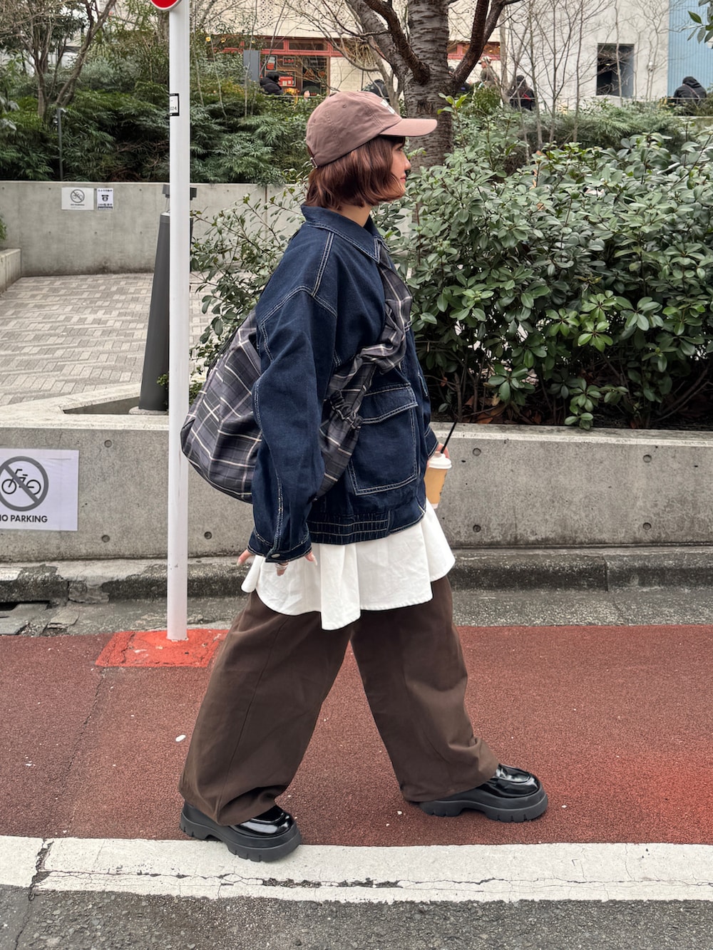 ブルー系のデニムジャケット、ブラック系のローファー、ブラウン系のチノパンツを着用したレディースの冬コーディネートの2枚目の写真