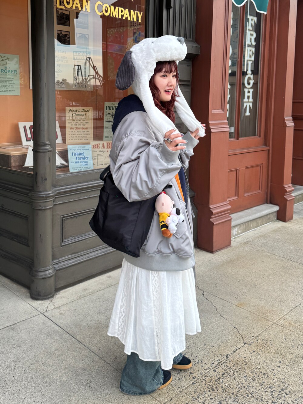 グレー系のMA-1、ブルー系のデニムパンツ、ブラック系のスニーカーを着用したレディースの冬コーディネートの2枚目の写真
