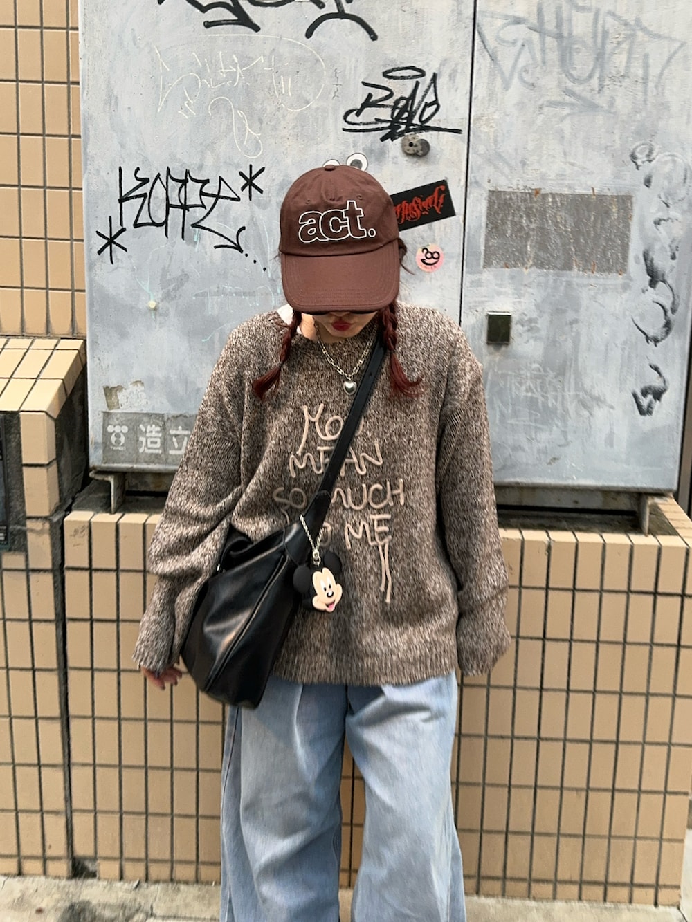 ブルー系のデニムパンツ、ブラウン系のスニーカーを着用したレディースの秋コーディネートの2枚目の写真