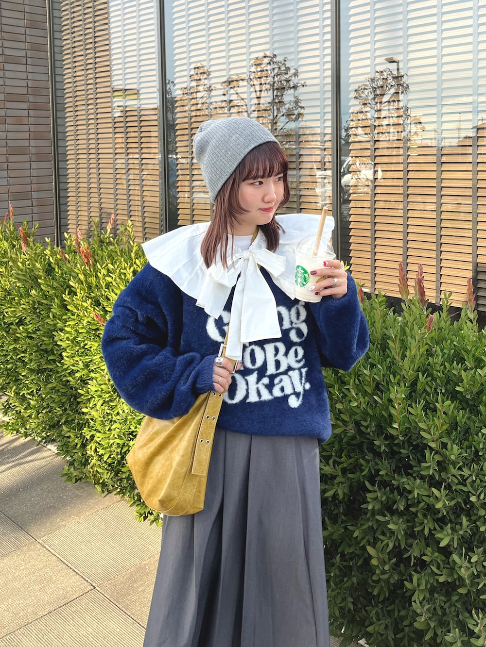 ブルー系のニット/セーター、イエロー系のショルダーバッグ、イエロー系のスニーカーを着用したレディースの冬コーディネートの3枚目の写真