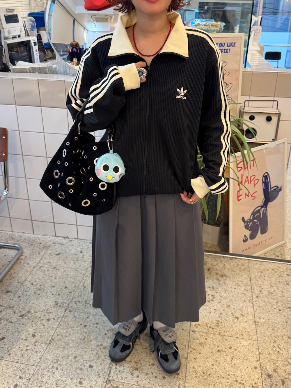 ブラック系のショルダーバッグ、ブラック系のジャージ、グレー系のスカートを着用したレディースの冬コーディネートの3枚目の写真