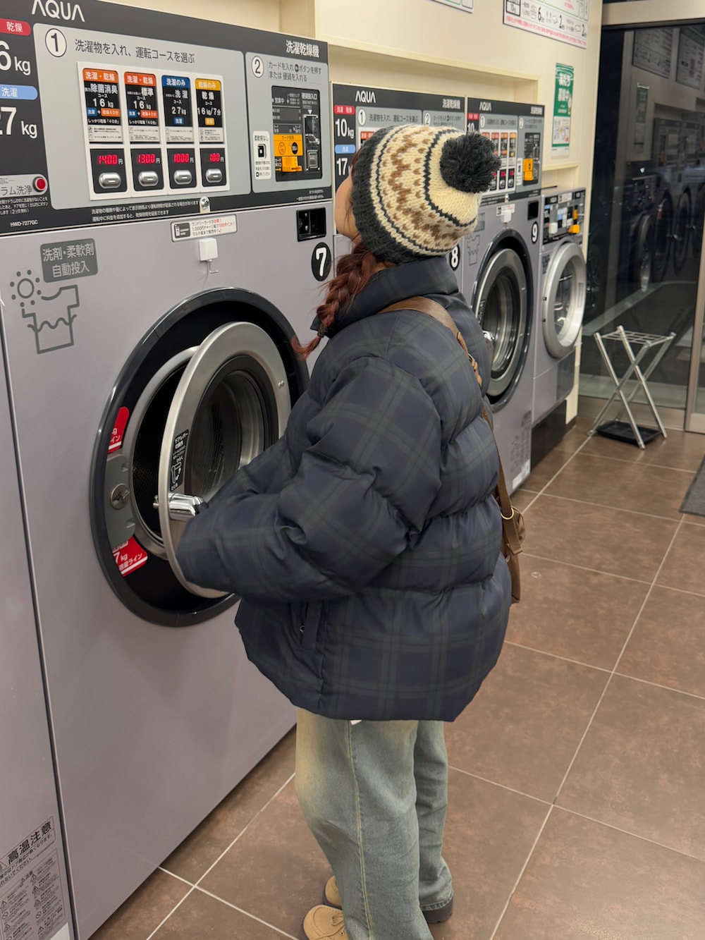 ベージュ系のモカシン/デッキシューズ、その他のダウンジャケット/コート、ブラウン系のショルダーバッグを着用したレディースの冬コーディネートの2枚目の写真