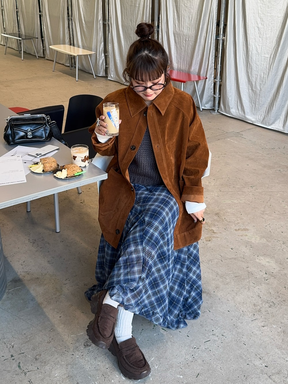ブラウン系のブルゾン、ブルー系のスカート、ブラウン系のローファーを着用したレディースの秋コーディネートの2枚目の写真