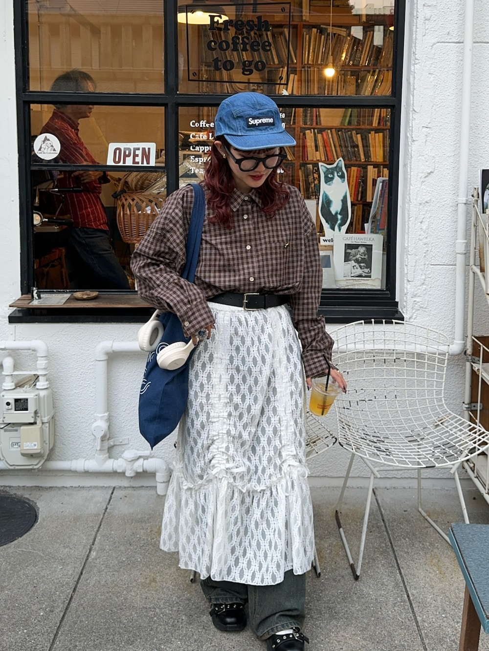 ブラウン系のシャツ/ブラウス、ホワイト系のスカート、ブルー系のキャップを着用したレディースの秋コーディネートの2枚目の写真
