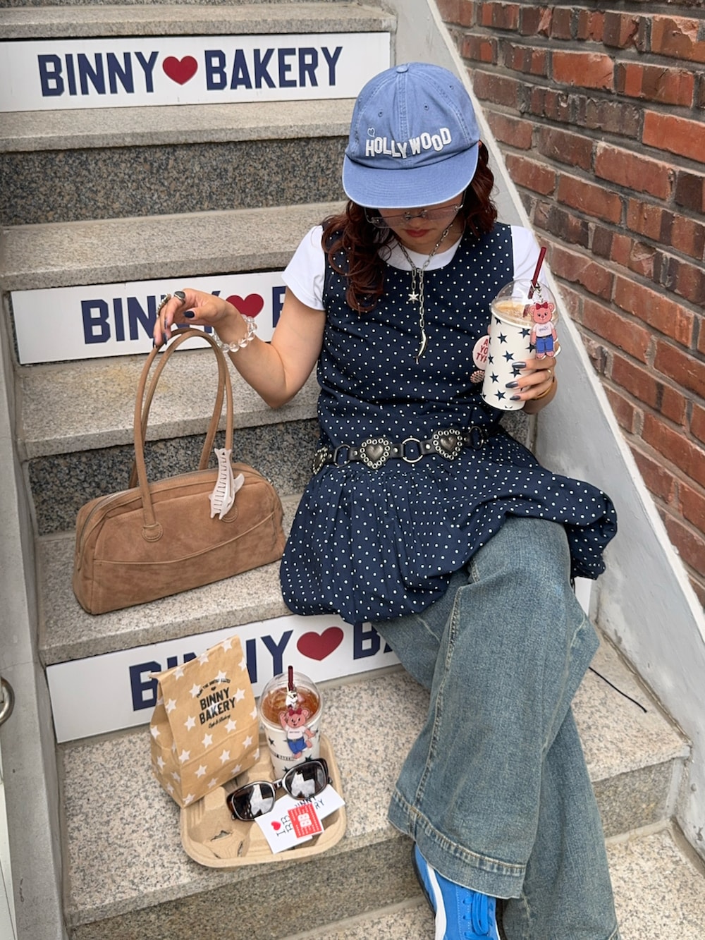 ベージュ系のボストンバッグ、ブルー系のデニムパンツ、ブルー系のワンピースを着用したレディースの夏コーディネートの2枚目の写真