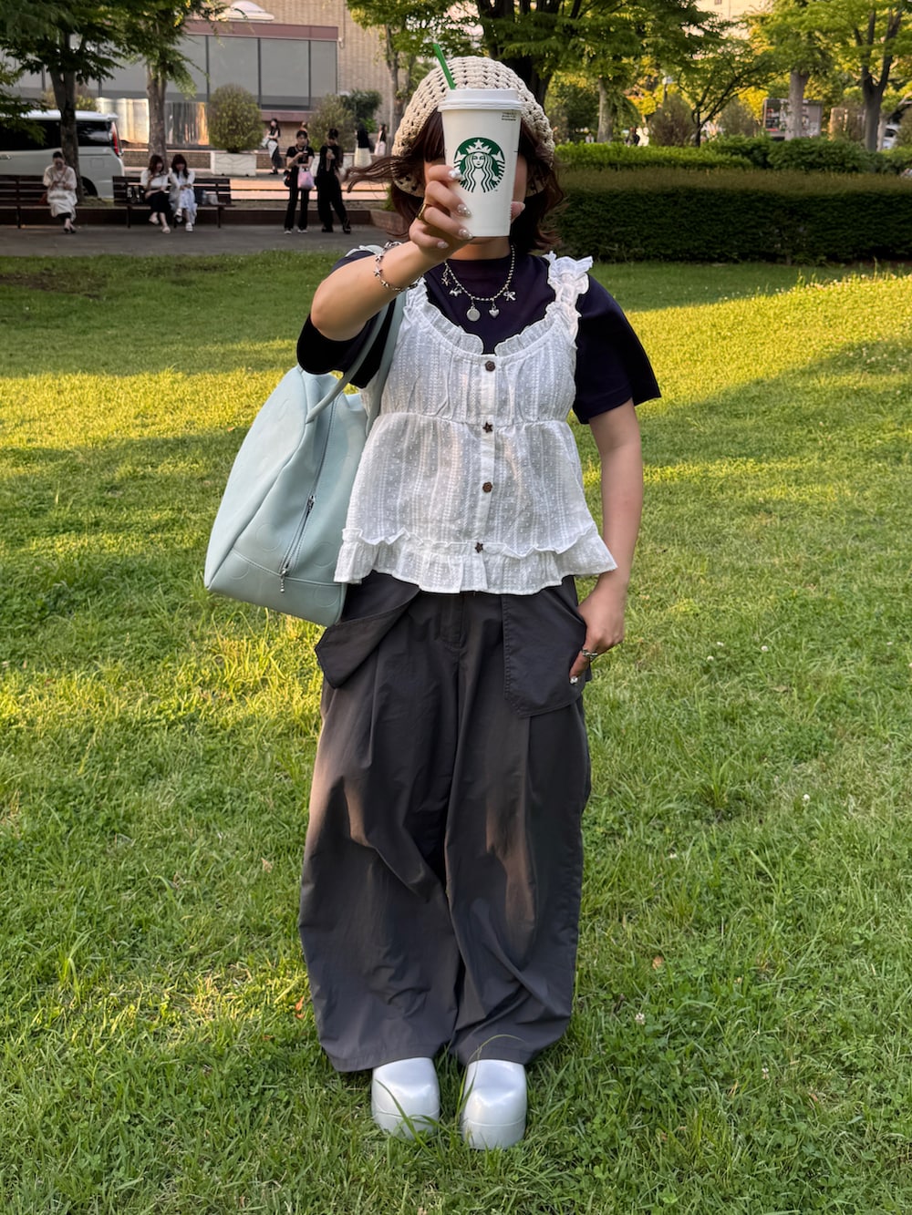 ブルー系のTシャツ/カットソー、ホワイト系のシャツ/ブラウス、グリーン系のボストンバッグを着用したレディースの夏コーディネートの2枚目の写真