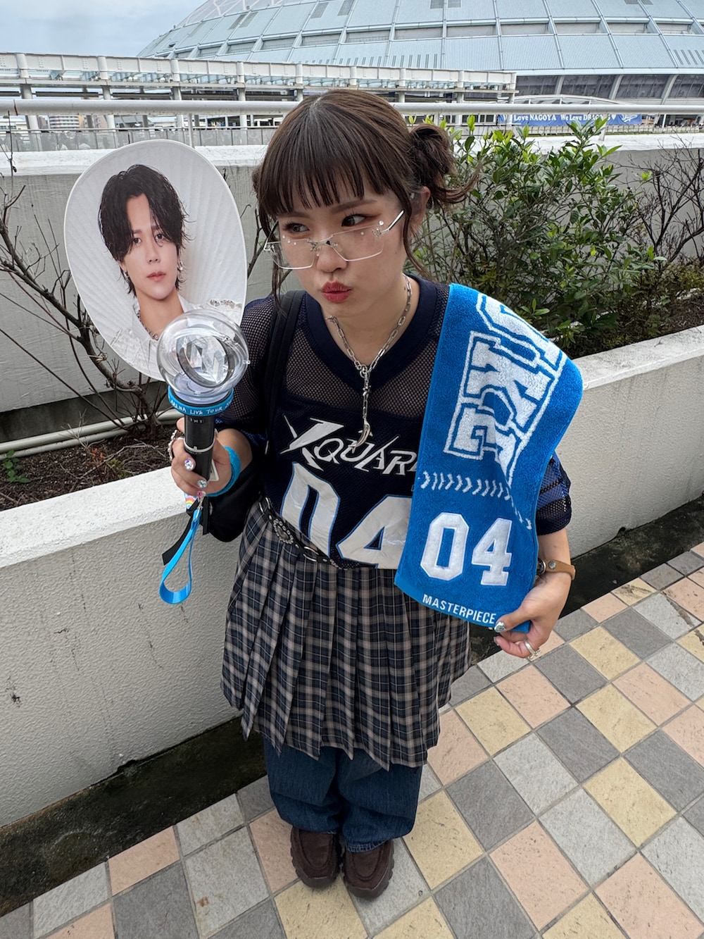 グレー系のスカート、ブラック系のトートバッグ、ブルー系のデニムパンツを着用したレディースの秋コーディネートの2枚目の写真