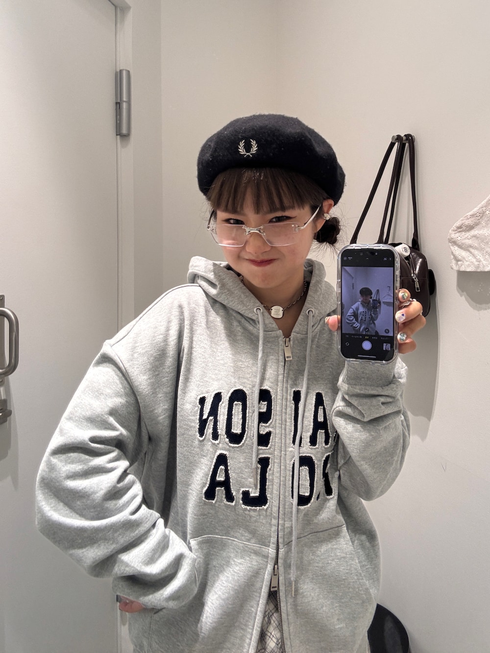 ホワイト系のスカート、ブルー系のデニムパンツ、ブラウン系のローファーを着用したレディースの秋コーディネートの2枚目の写真