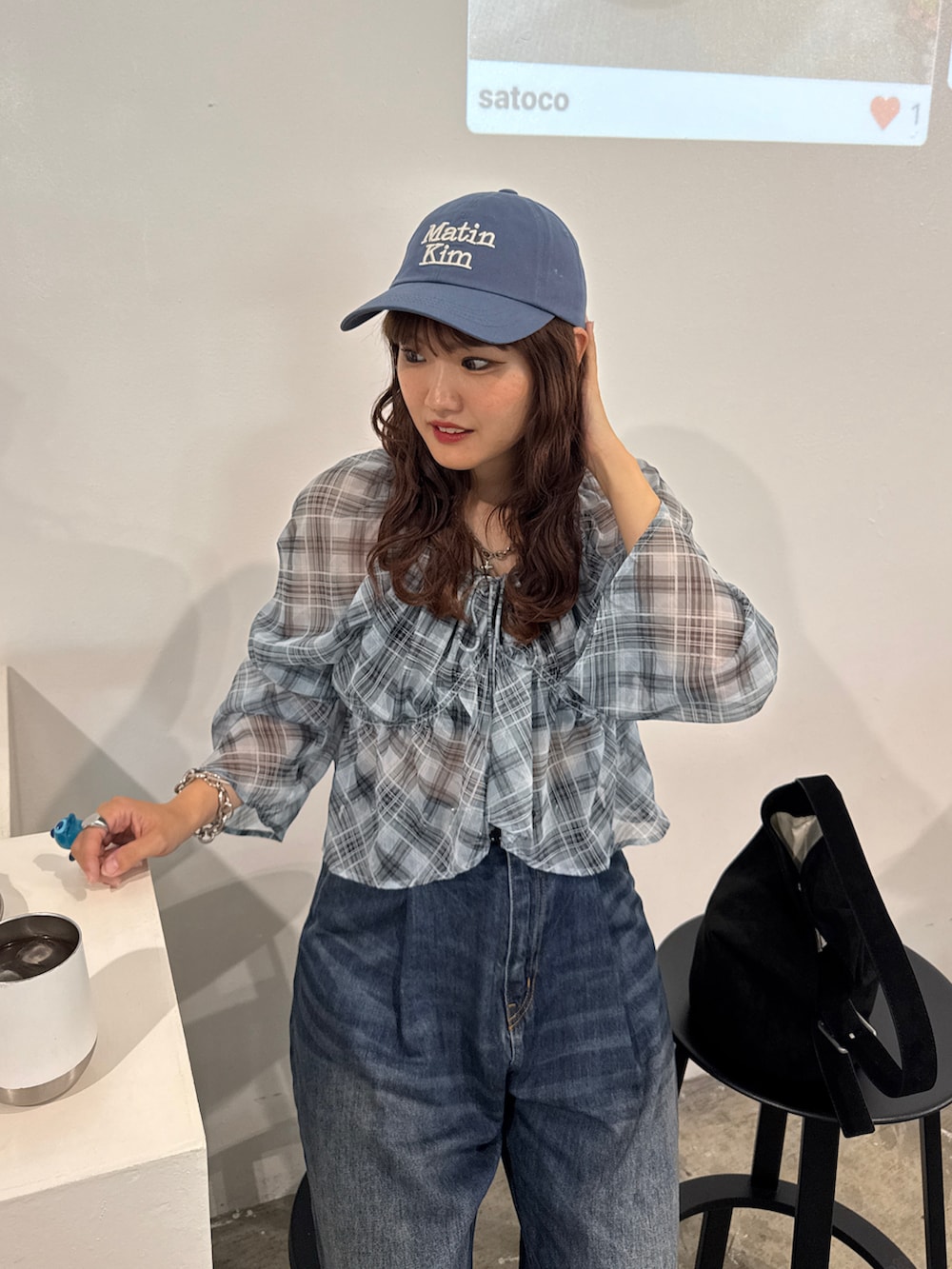 ブルー系のシャツ/ブラウス、ブルー系のデニムパンツ、ブラック系のハンドバッグを着用したレディースの夏コーディネートの2枚目の写真