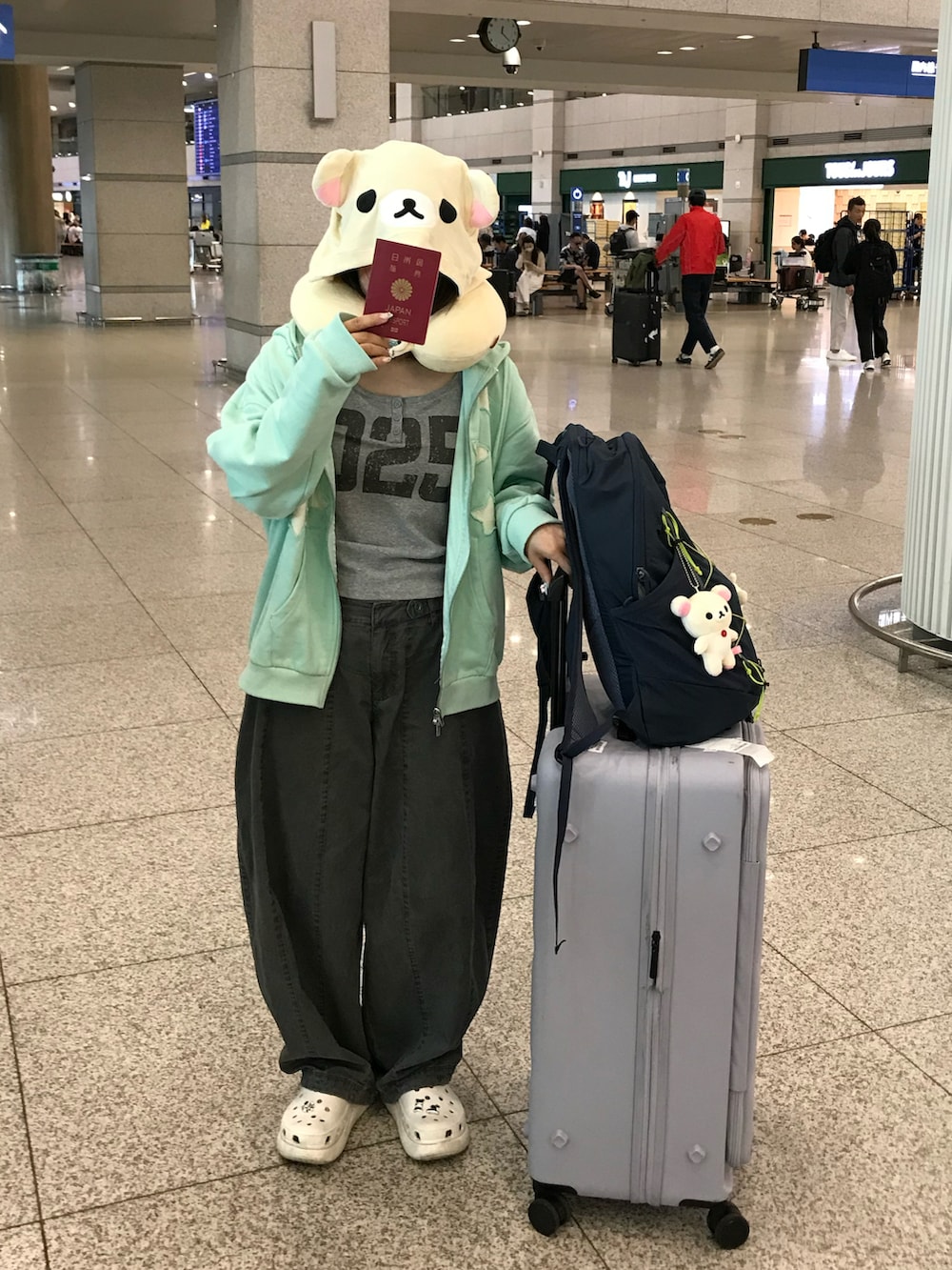 ブルー系のバックパック/リュック、グレー系のカーゴパンツ、ホワイト系のサンダルを着用したレディースの夏コーディネートの2枚目の写真