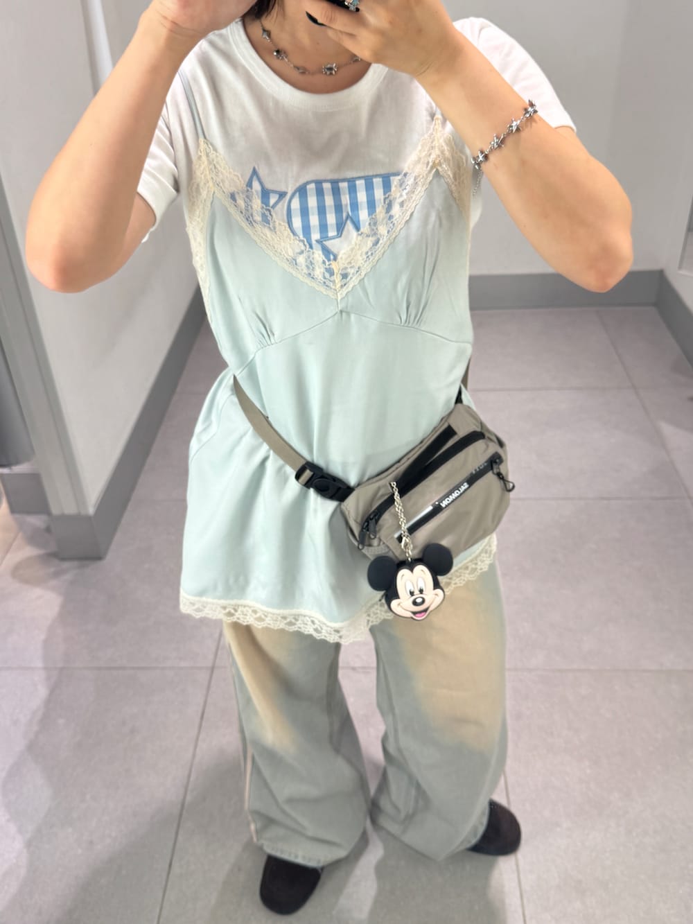 ブルー系のデニムパンツ、ブルー系のキャミソール、グレー系のボディバッグ/ウエストポーチを着用したレディースの夏コーディネートの2枚目の写真