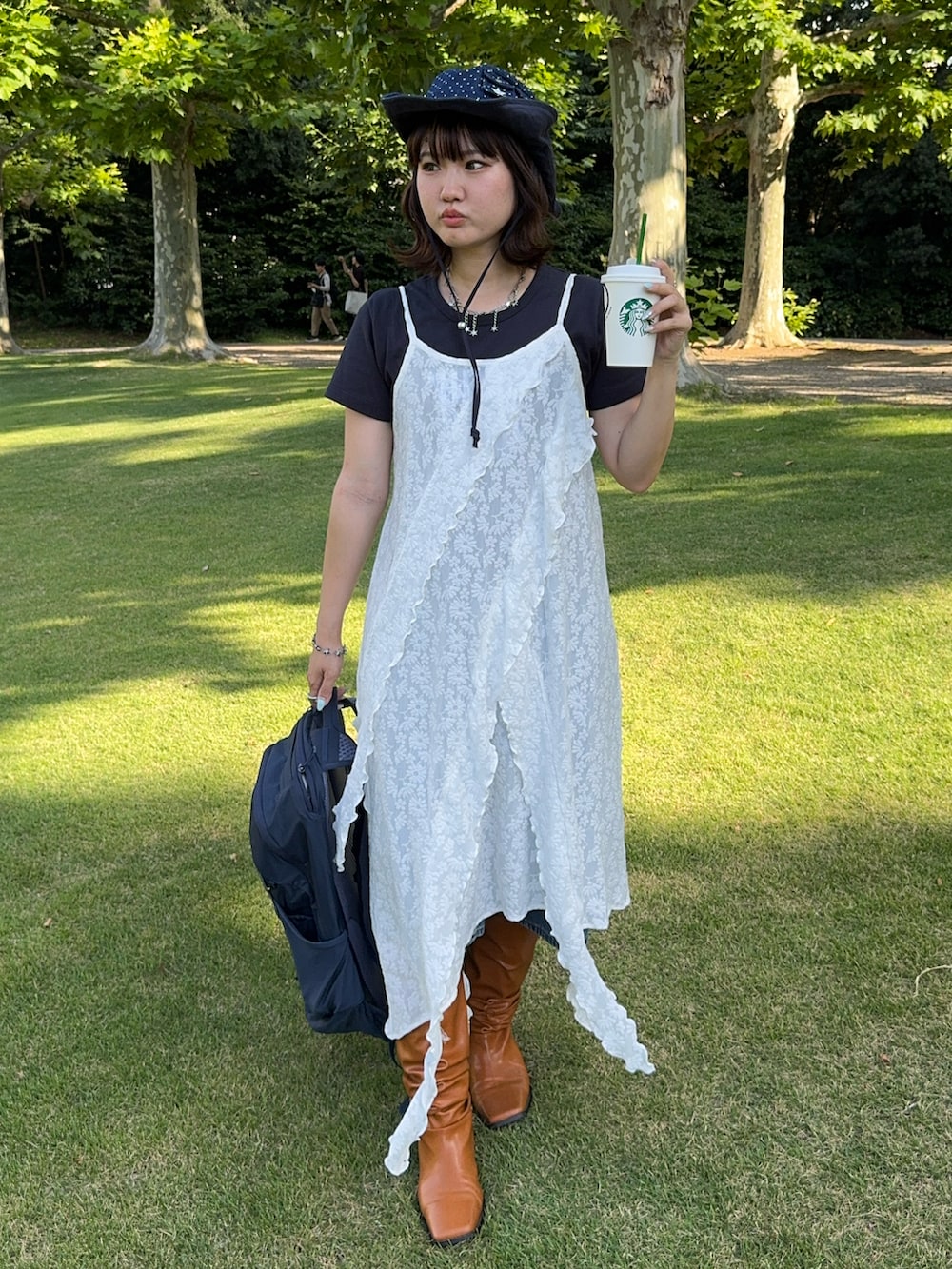 ブルー系のバックパック/リュック、ブラウン系のブーツ、ブルー系の帽子を着用したレディースの夏コーディネートの2枚目の写真