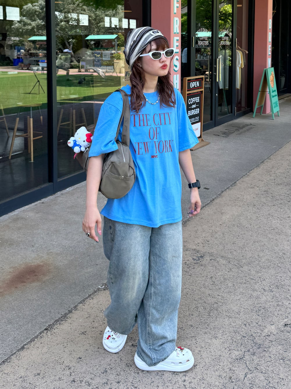 ホワイト系のサンダル、ブルー系のTシャツ/カットソー、ブルー系のデニムパンツを着用したレディースの夏コーディネートの3枚目の写真