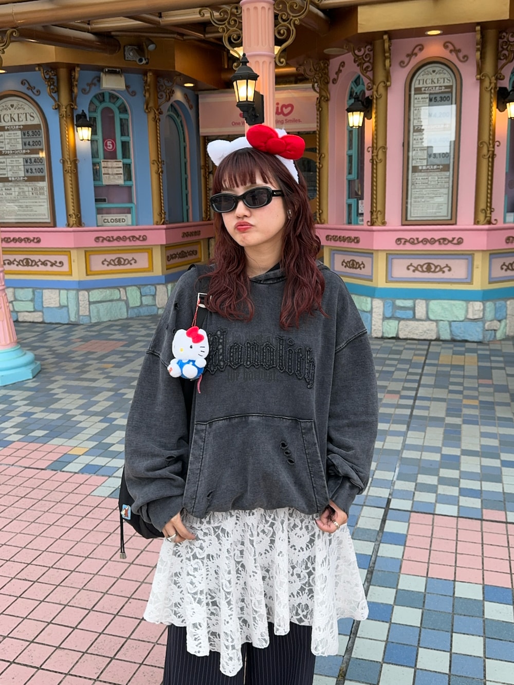 レッド系のスニーカー、ブルー系のスラックス、グレー系のパーカーを着用したレディースの秋コーディネートの2枚目の写真