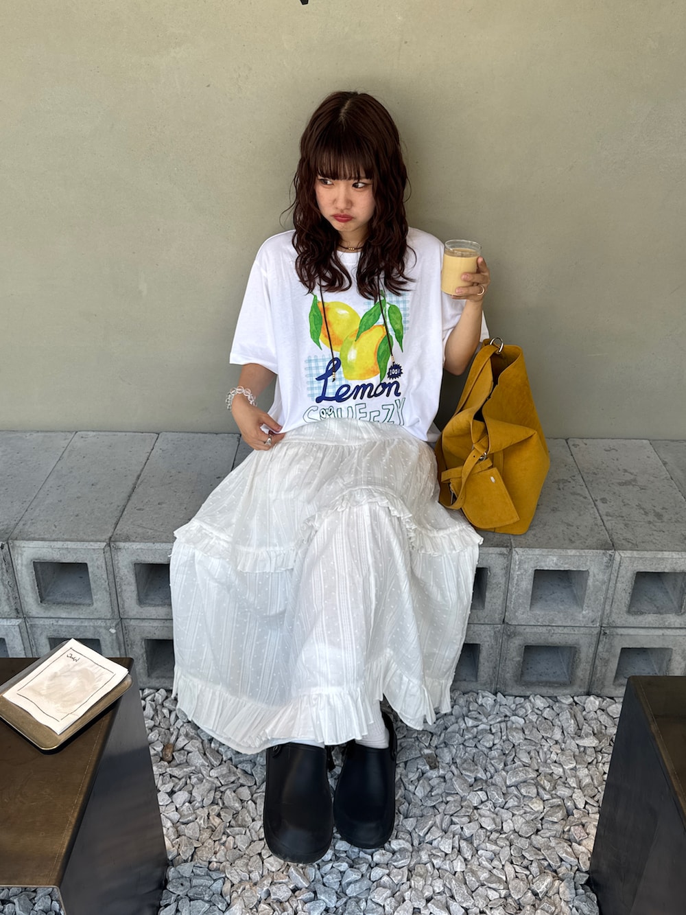 ホワイト系のスカート、ホワイト系のTシャツ/カットソー、イエロー系のショルダーバッグを着用したレディースの夏コーディネートの2枚目の写真