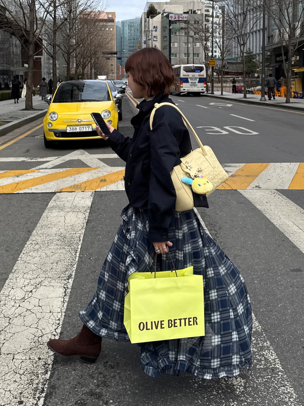 ブルー系のスカート、ブルー系のブルゾン、ブラウン系のブーツを着用したレディースの春コーディネートの2枚目の写真