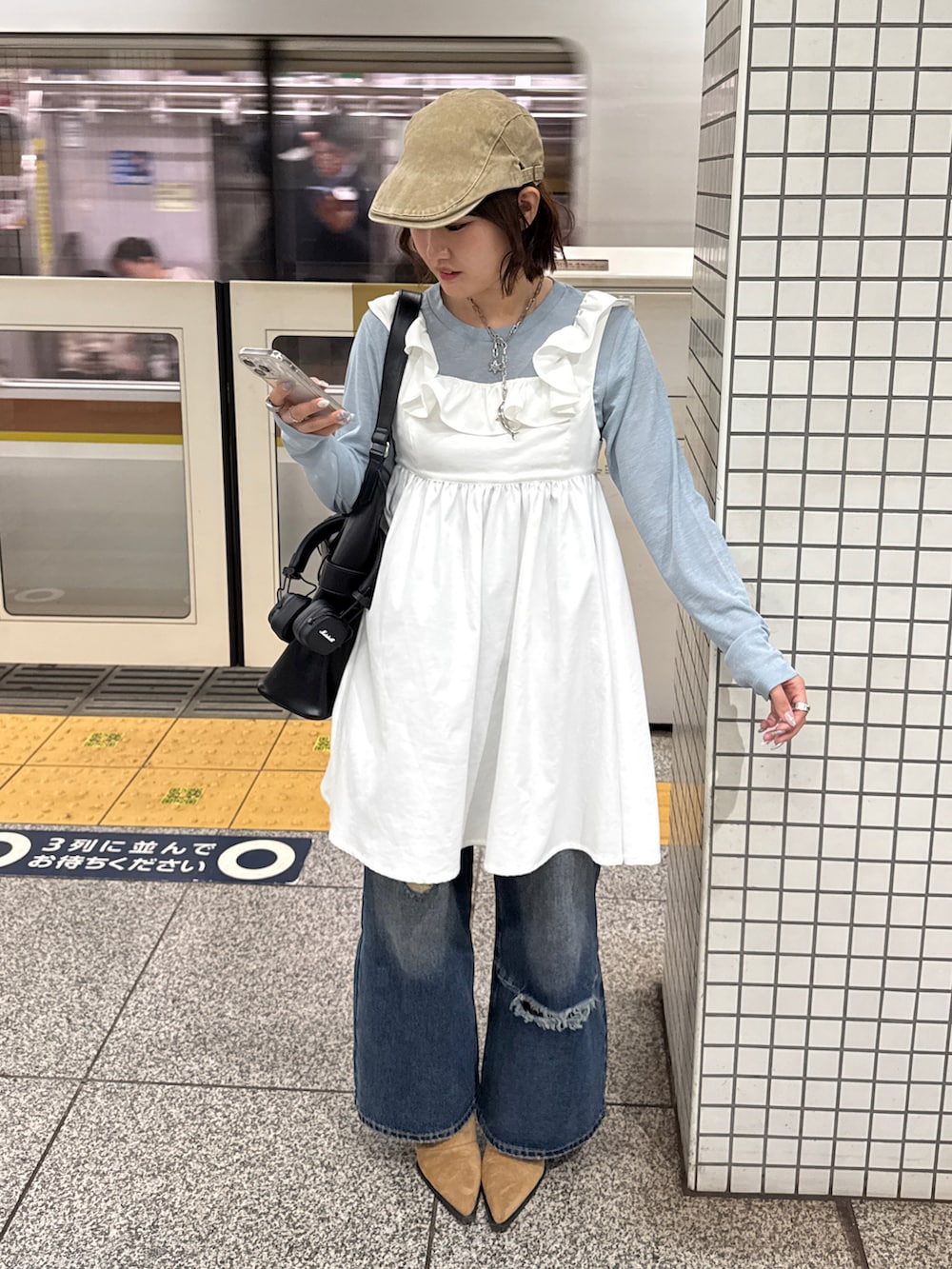 ブルー系のデニムパンツ、ブルー系のTシャツ/カットソー、ホワイト系のチュニックを着用したレディースの冬コーディネートの2枚目の写真