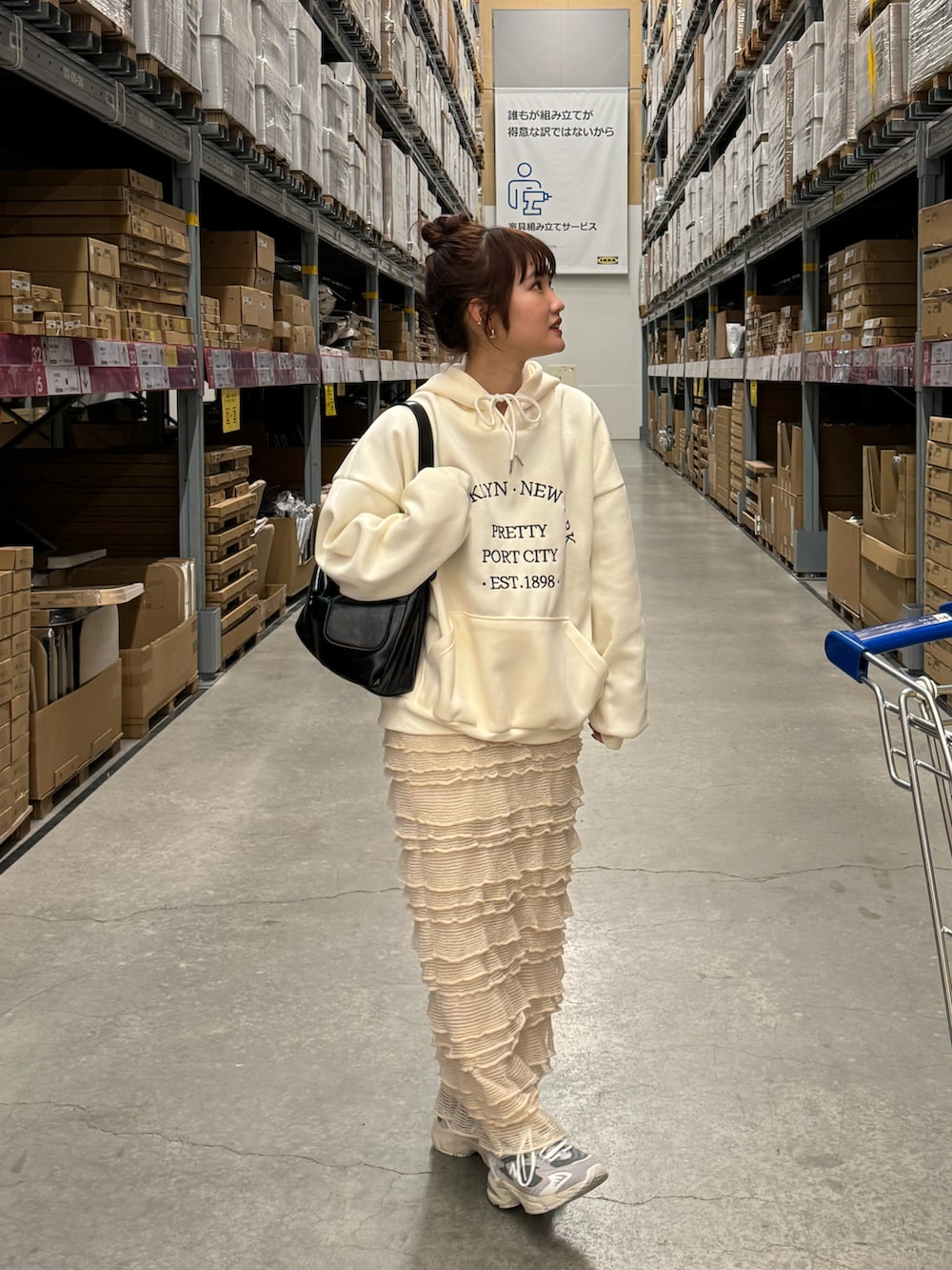 グレー系のスニーカー、ホワイト系のパーカー、ベージュ系のスカートを着用したレディースの冬コーディネートの2枚目の写真