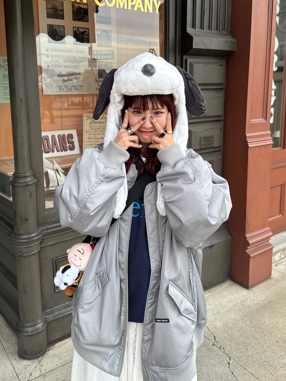 グレー系のMA-1、ブルー系のデニムパンツ、ブラック系のスニーカーを着用したレディースの冬コーディネートの3枚目の写真