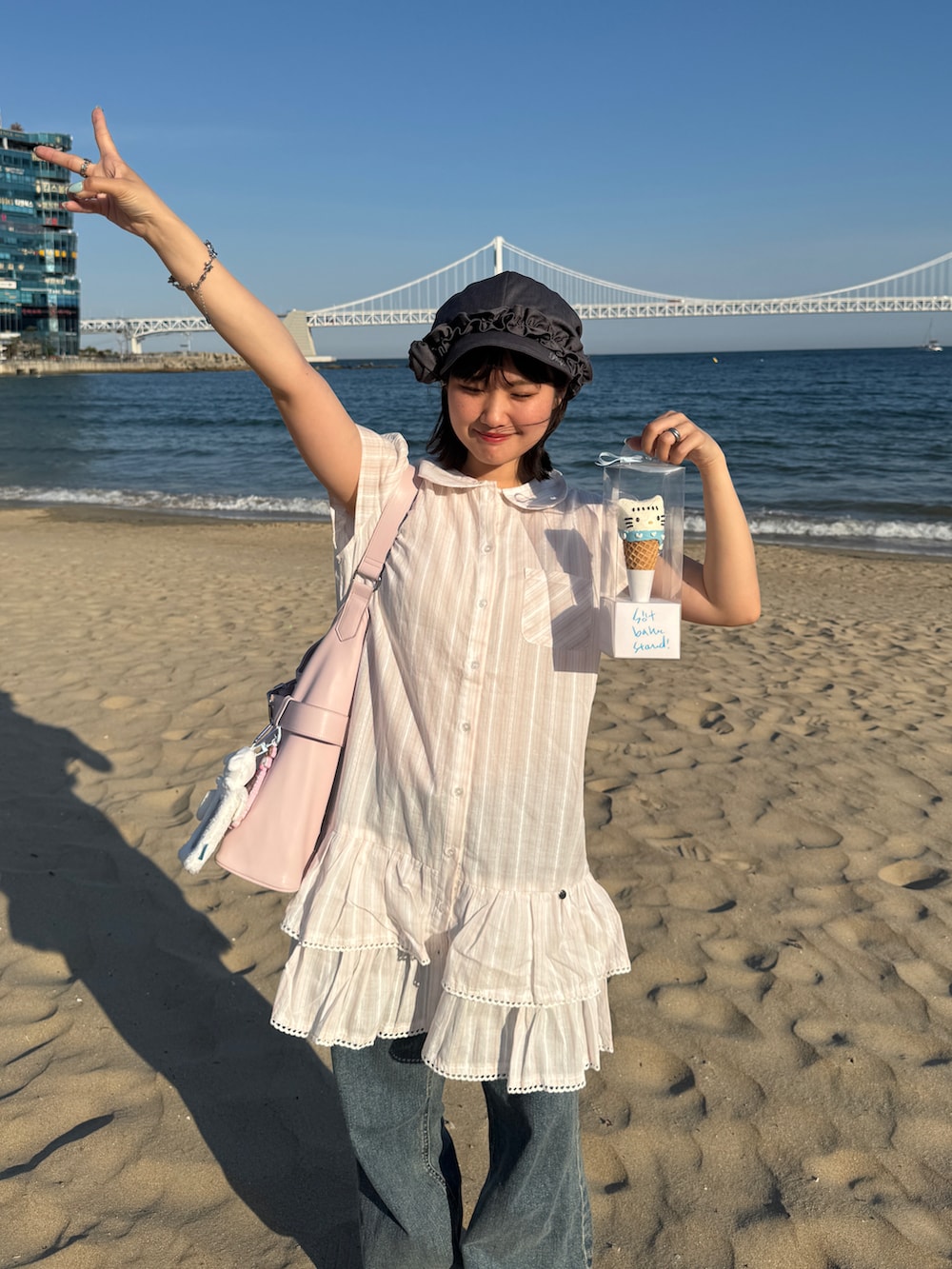 ブラック系のスニーカー、ブルー系のデニムパンツ、その他のワンピースを着用したレディースの春コーディネートの2枚目の写真