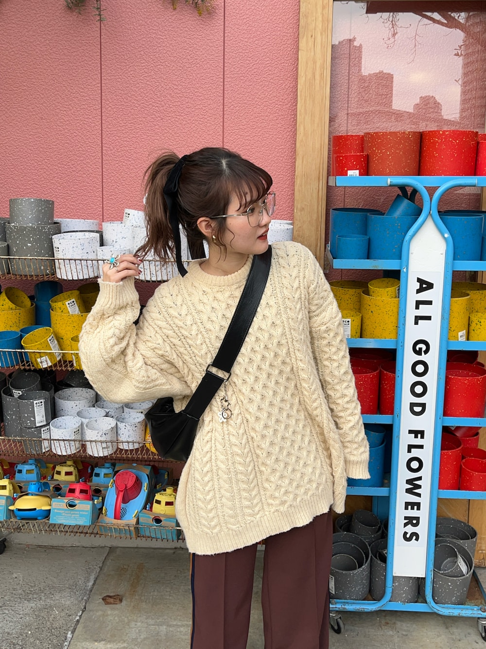 グレー系のスニーカー、ブラウン系のスラックス、ベージュ系のニット/セーターを着用したレディースの冬コーディネートの2枚目の写真