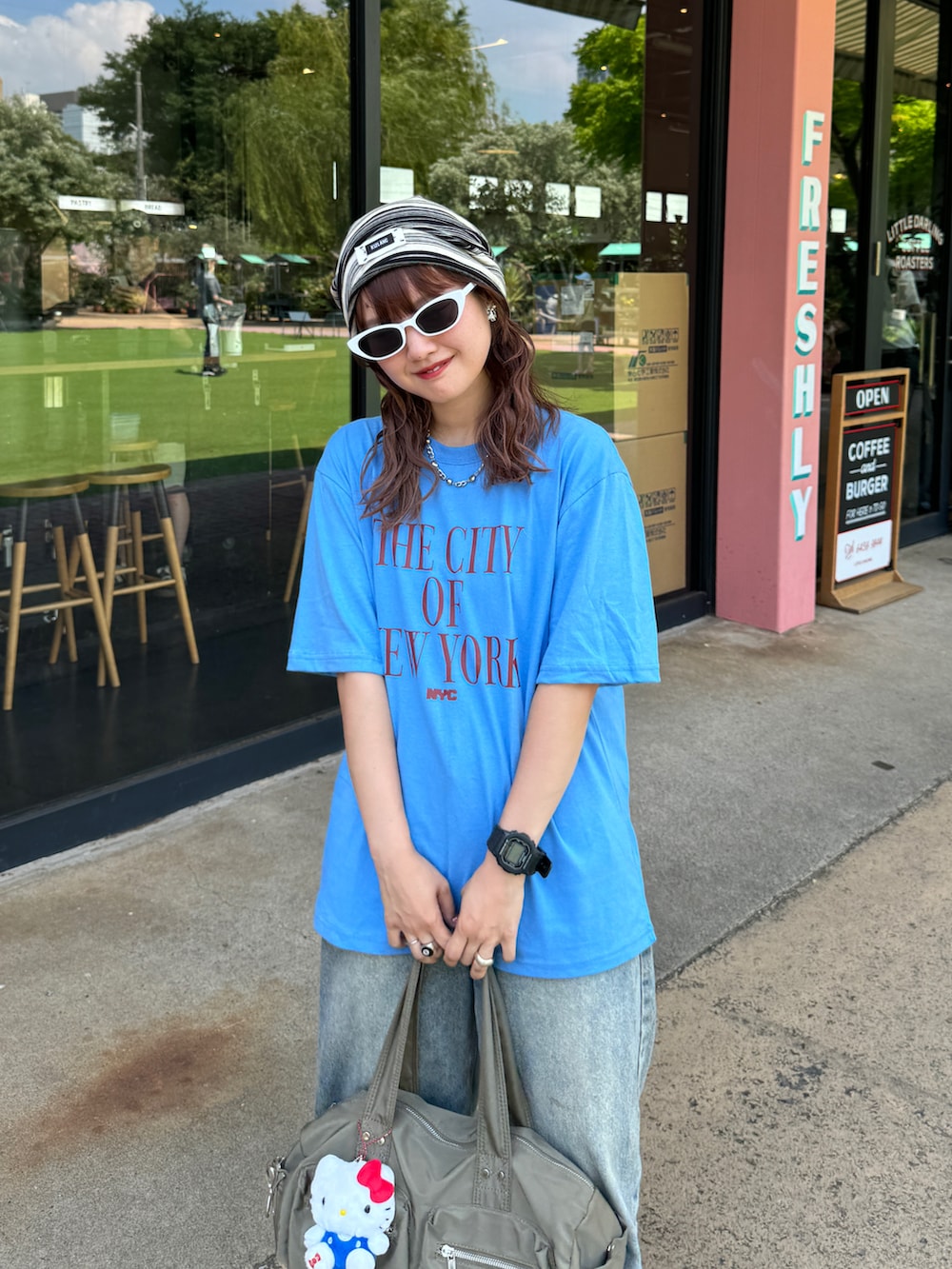 ホワイト系のサンダル、ブルー系のTシャツ/カットソー、ブルー系のデニムパンツを着用したレディースの夏コーディネートの2枚目の写真