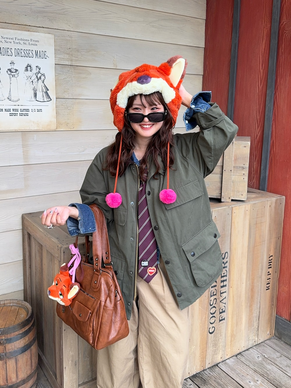 ブラウン系のショルダーバッグ、グリーン系のブルゾン、ブラウン系のブーツを着用したレディースの秋コーディネートの2枚目の写真