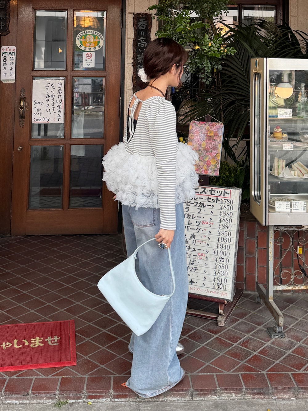 グレー系のTシャツ/カットソー、ブルー系のデニムパンツを着用したレディースの春コーディネートの2枚目の写真