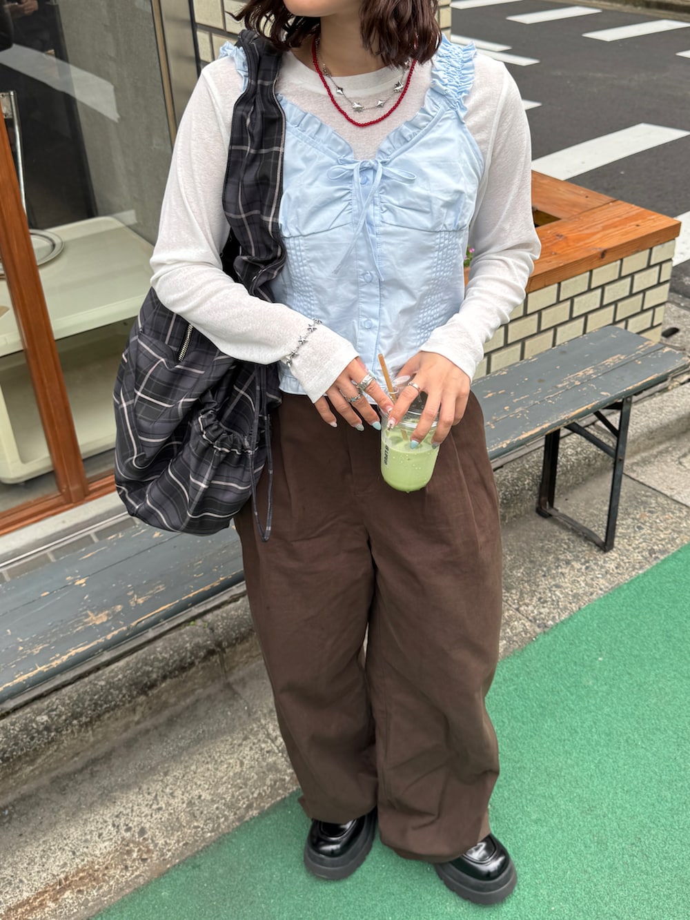 ブラック系のローファー、ブルー系のその他トップス、ブラウン系のチノパンツを着用したレディースの夏コーディネートの2枚目の写真