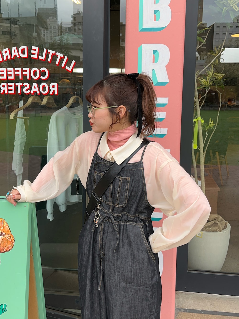 ベージュ系のシャツ/ブラウス、ブラック系のオールインワン・サロペット、ホワイト系のスニーカーを着用したレディースの冬コーディネートの2枚目の写真