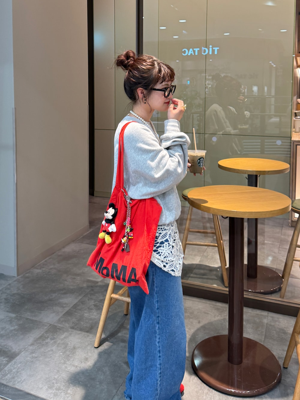 ブルー系のデニムパンツ、グレー系のスウェット、レッド系のスニーカーを着用したレディースの春コーディネートの2枚目の写真