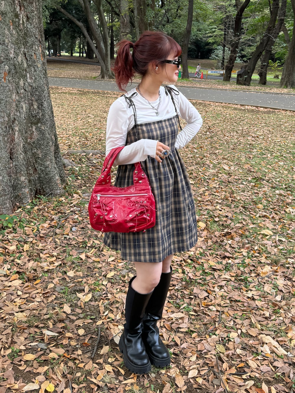 ブラック系のブーツ、レッド系のハンドバッグ、ホワイト系のTシャツ/カットソーを着用したレディースの秋コーディネートの2枚目の写真