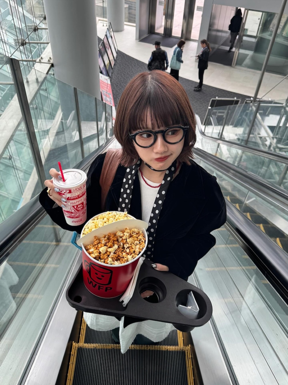 ホワイト系のスカート、ブラック系のテーラードジャケット、ブラウン系のブーツを着用したレディースの秋コーディネートの2枚目の写真