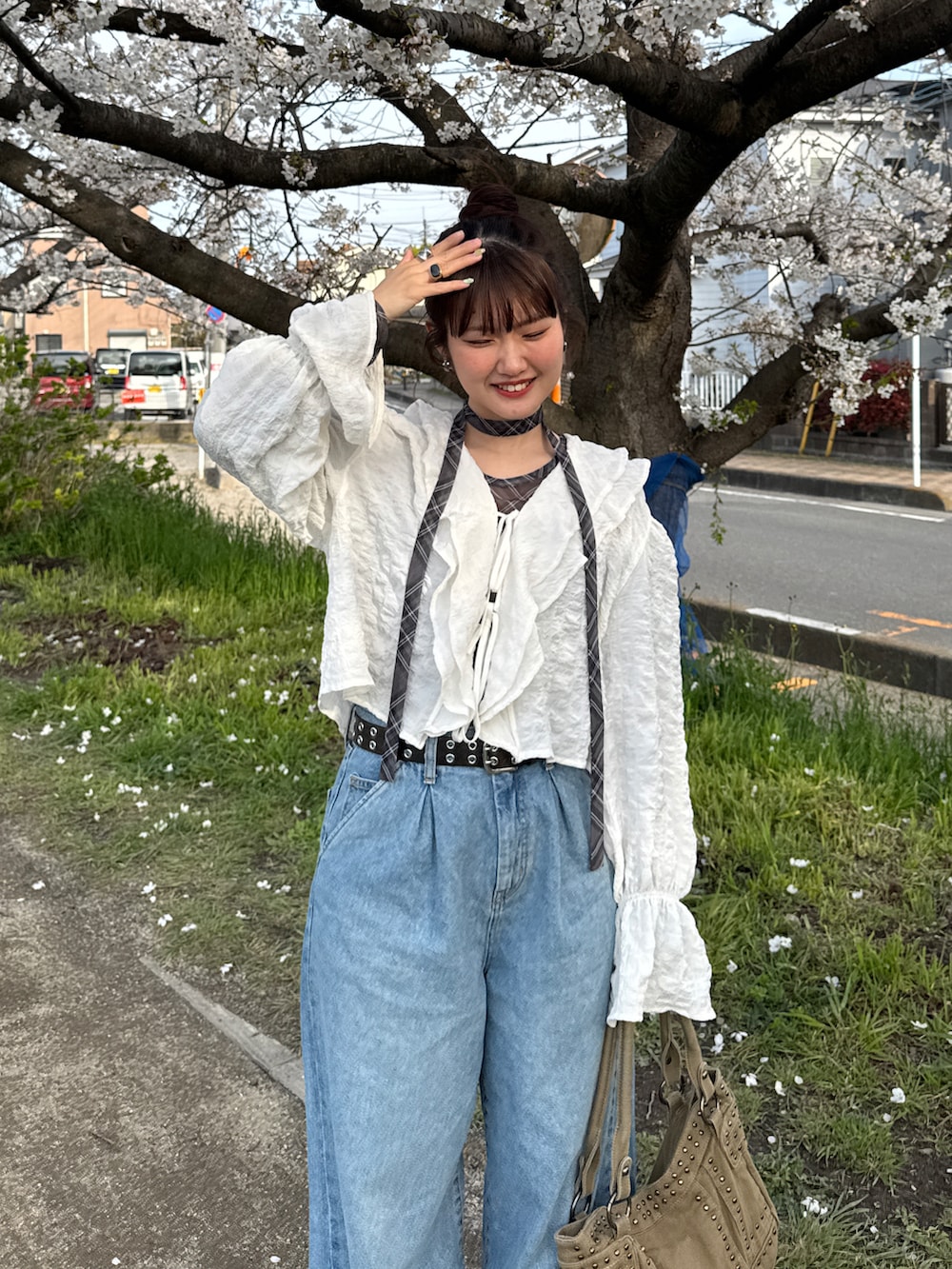 ブルー系のデニムパンツ、ホワイト系のシャツ/ブラウス、グレー系のTシャツ/カットソーを着用したレディースの春コーディネートの2枚目の写真