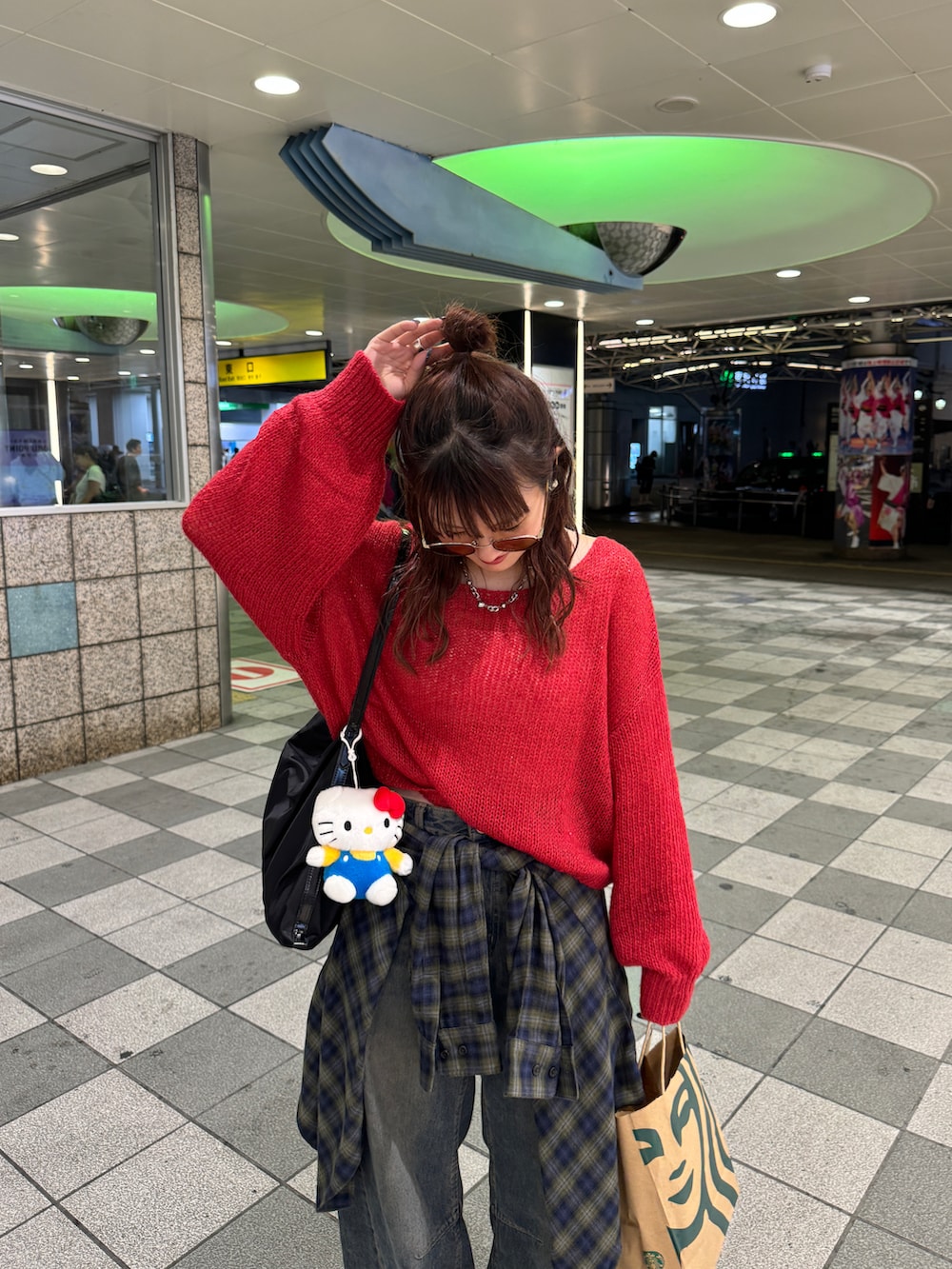 レッド系のニット/セーター、ブラック系のローファー、ブルー系のデニムパンツを着用したレディースの秋コーディネートの2枚目の写真