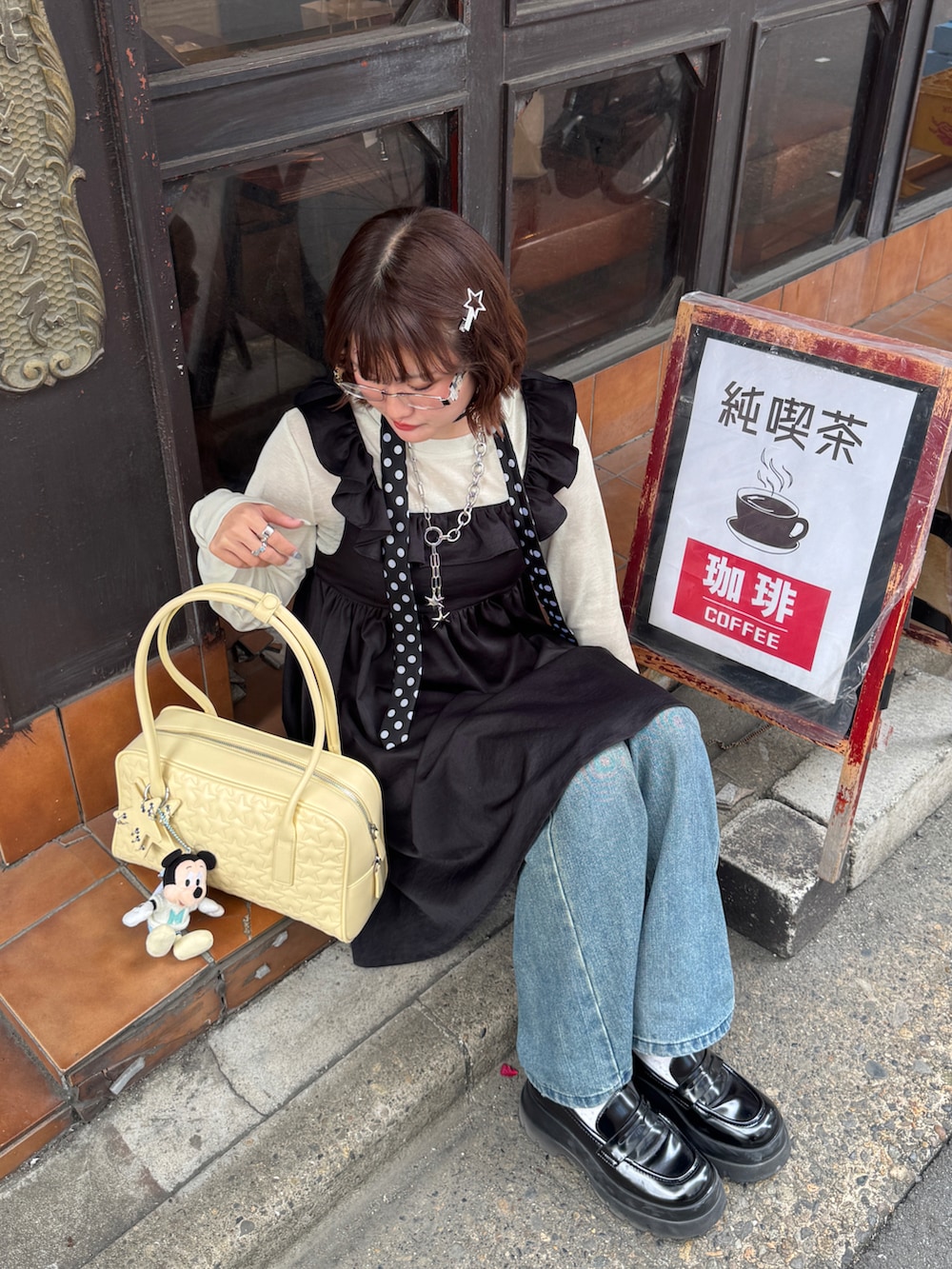 ブルー系のデニムパンツ、ブラック系のローファー、ブラック系のネクタイを着用したレディースの冬コーディネートの2枚目の写真