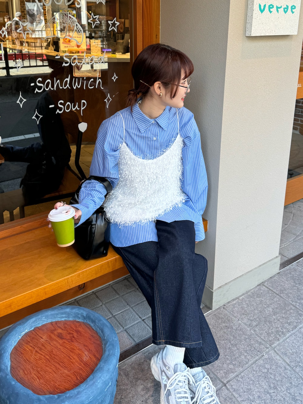 ブルー系のデニムパンツ、グレー系のスニーカー、ブルー系のシャツ/ブラウスを着用したレディースの春コーディネートの3枚目の写真