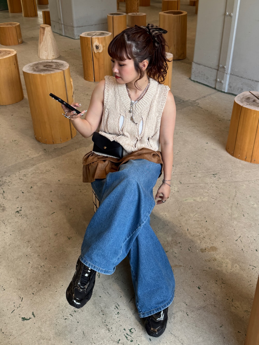 ホワイト系のベスト、ブルー系のデニムパンツ、ブラック系のボディバッグ/ウエストポーチを着用したレディースの夏コーディネートの3枚目の写真