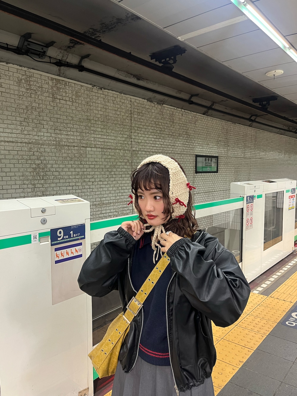 イエロー系のショルダーバッグ、ブラック系のニット/セーター、ブラック系のジャケット/アウターを着用したレディースの冬コーディネートの3枚目の写真